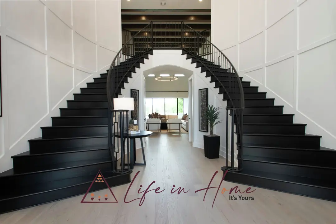Grand colonial plantation style double-flight staircase with polished mahogany wood and white balusters—luxury foyer design for a Coimbatore villa.