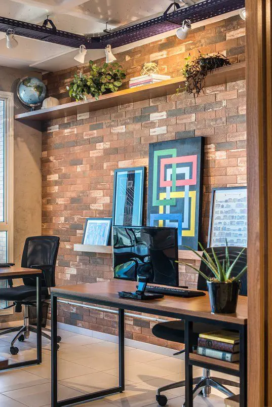 Industrial style farmhouse study with exposed brick walls, metal-framed windows, and a reclaimed wood desk—modern office design in Anaikatti.