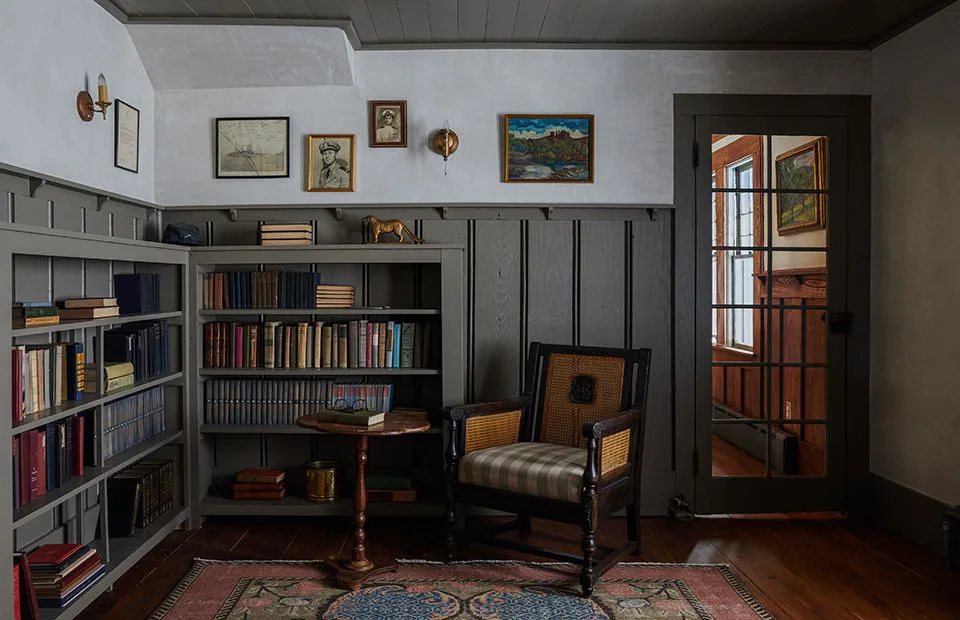 Classic farmhouse study featuring floor-to-ceiling teak wood bookshelves and a vintage leather armchair—heritage library design in Siruvani.