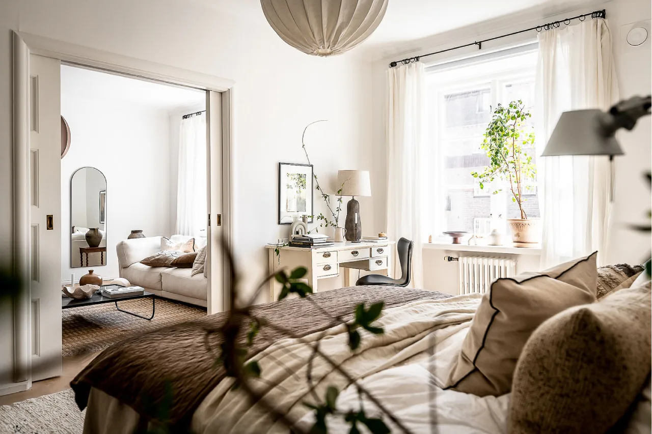 Minimalist Scandi-Zen bedroom with light oak wood floors, neutral linen bedding, and an airy white aesthetic—modern vacation home in Narasimukku.