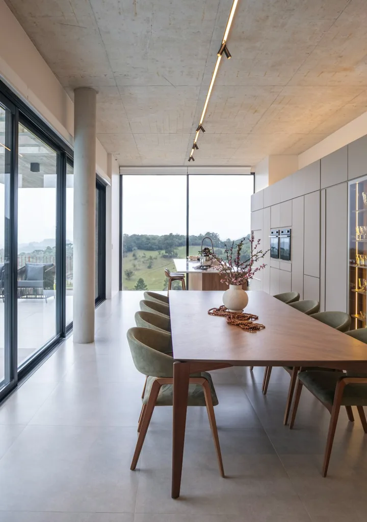 Modern glass-wrapped dining room with floor-to-ceiling windows and garden views—contemporary luxury farmhouse in Anaikatti, Coimbatore.