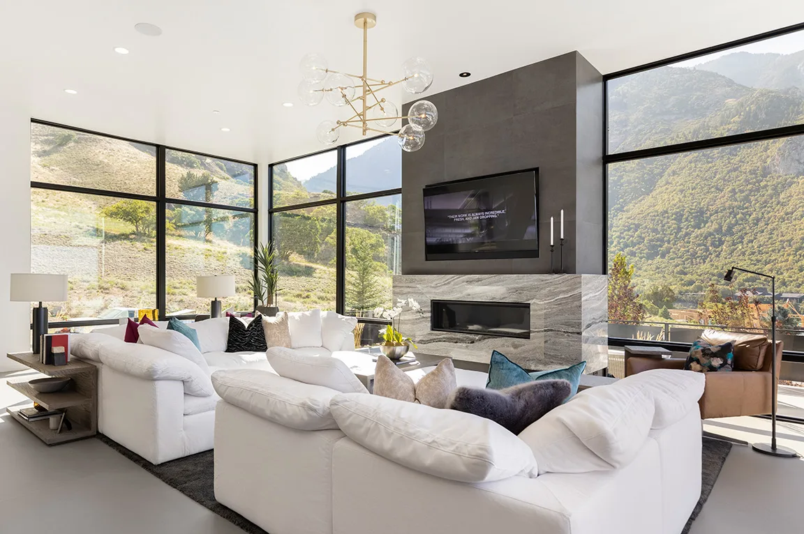 Modern farmhouse living room with floor-to-ceiling glass walls overlooking the Western Ghats—luxury NRI lounge design in Anaikatti, Coimbatore.