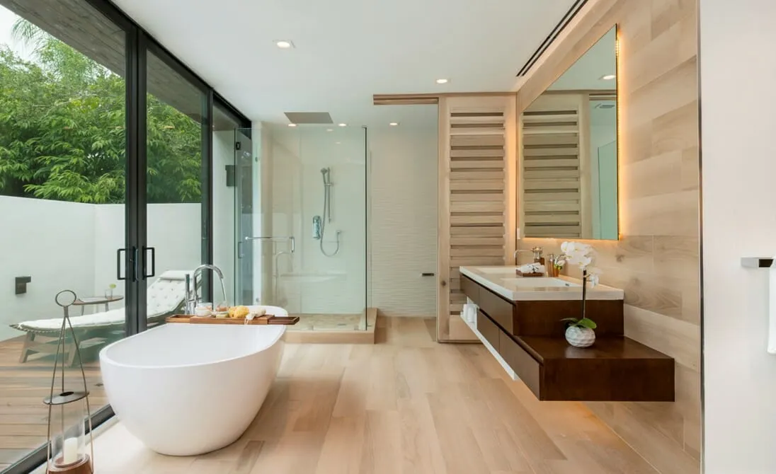 Luxury modern farmhouse bathroom with floor-to-ceiling glass walls and a freestanding tub—panoramic mountain views in Anaikatti, Coimbatore.